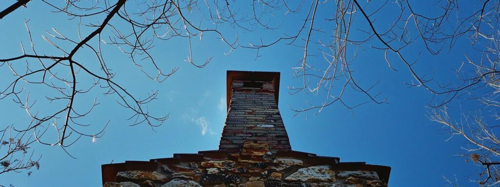 a well-maintained chimney rises against a clear blue sky, symbolizing the importance of affordable chimney inspections in ensuring safety and longevity in new jersey homes.